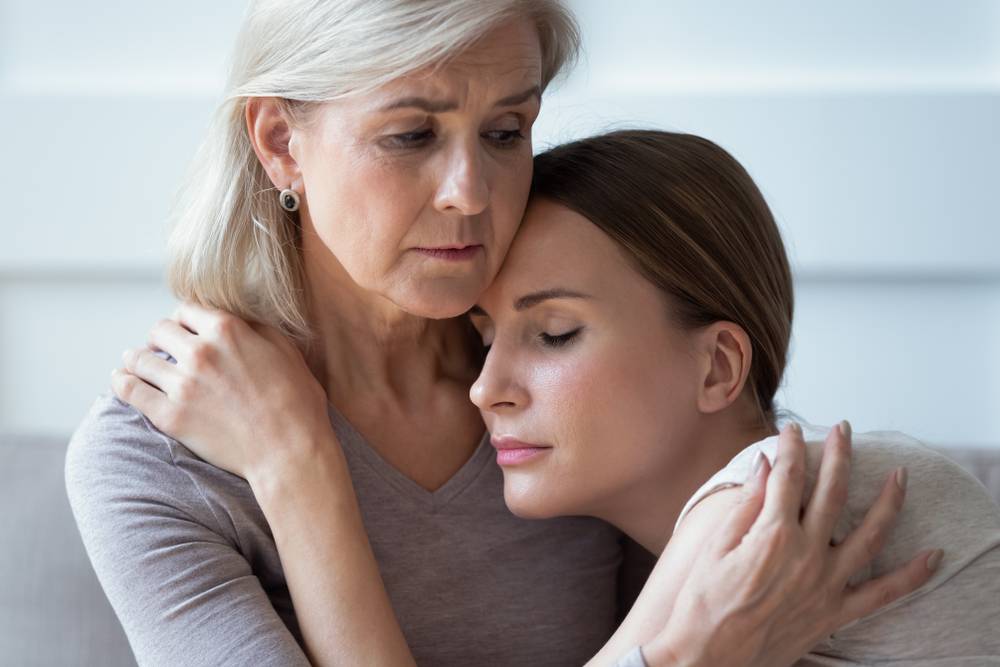 Una mujer mayor consolando a una mujer más joven después de la pérdida de un ser querido